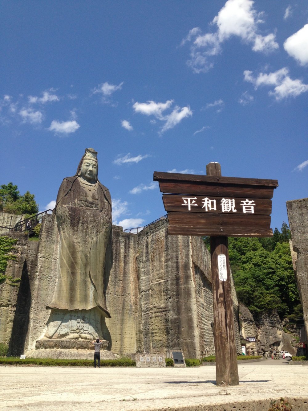 A lone visitor stands under the Peace Kannon