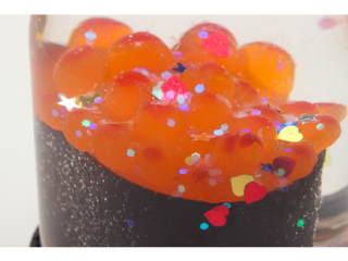 A close up as the glitter falls on the salmon egg roe.&nbsp;