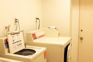 The laundry room has two washing machines and a dryer.