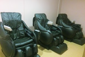 Three massage chairs outside of the onsen