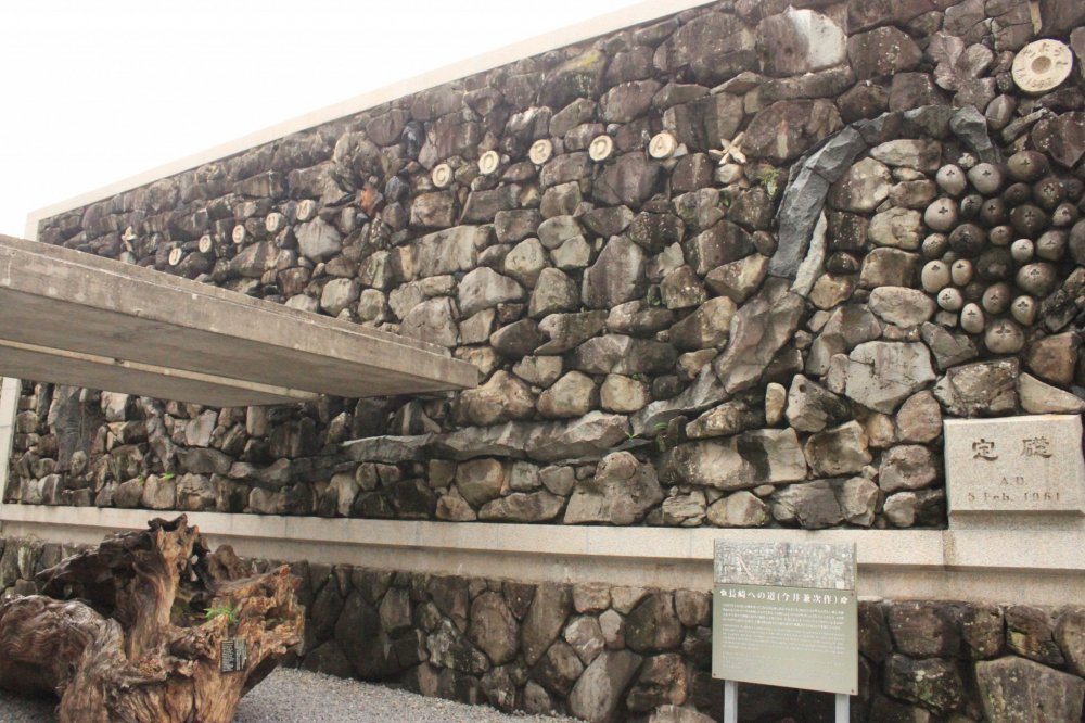 At the back of the monument is a stone wall designed by Architect Kenji Imai, depicting the month-long pilgrimage of the 26 Martyrs from Kyoto to Nagasaki.