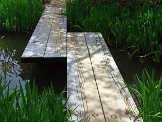 A simple bridge of wooden planks allows visitors to cross this small stream.