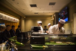 Chefs preparing the sushi behind the counter