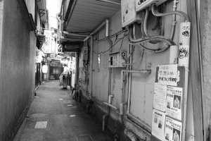 A tight alley squeezed between rampaging tall buildings where traditional Japanese and Chinese restaurants still exist