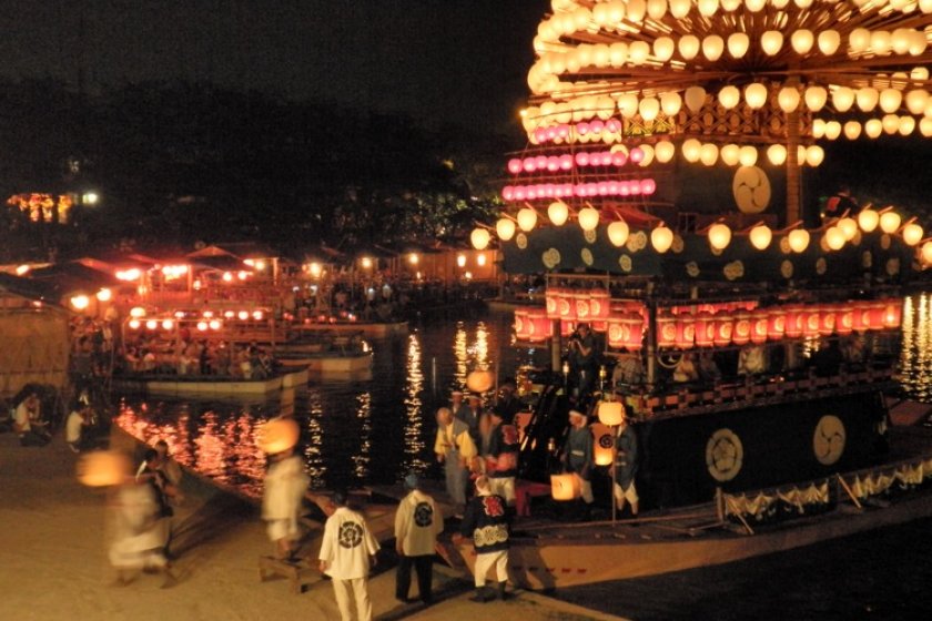 Makiwara boats with lanterns ablaze.