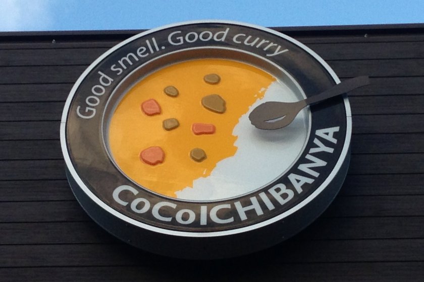 Coco ICHIBANYA'S sign accurately depicts its curry dishes; rice on one side with curry poured onto the other side of the plate
