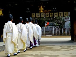 Just before the start of a ceremony, Shinto priests walk into the sanctuary