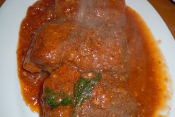 <p>Chef&#39;s special: tender marinated pork baked in a tomato sauce. We used plain pizza bread to clean the plate. I say the pizza was filling BUT admittedly, we indulged in other dishes such as this one</p>