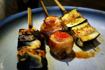 <p>Pork wrapped tomato flanked by tsukune stuffed eggplant.</p>