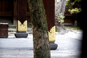 <p>Peeping through the side wooden fence inside Kara-Mon (main gate) of Toyokuni Shrine. I came late and the gate was closed. Here again, golden Paulownia decorate wooden pillars</p>