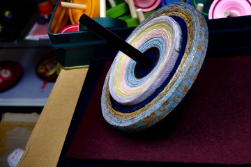 <p>Beautiful spinning top made of Nishijin Kimono Sash fabric. I asked if it&#39;s made by &#39;leftovers&#39; of Kimono Sash, as Nishijin Sash is very expensive, but according to the Maestro, the material was custom-made just for this Koma, the spinning top!</p>