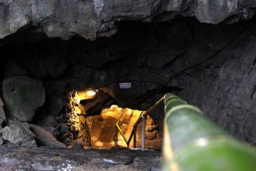<p>The entrance to the cave has a warning sign and some slippery stairs made of natural rocks.</p>