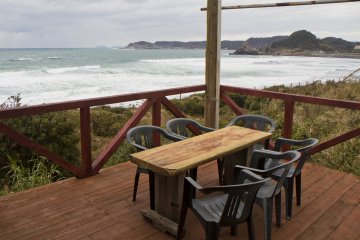 <p>Outdoor seating looks onto the incoming waves</p>