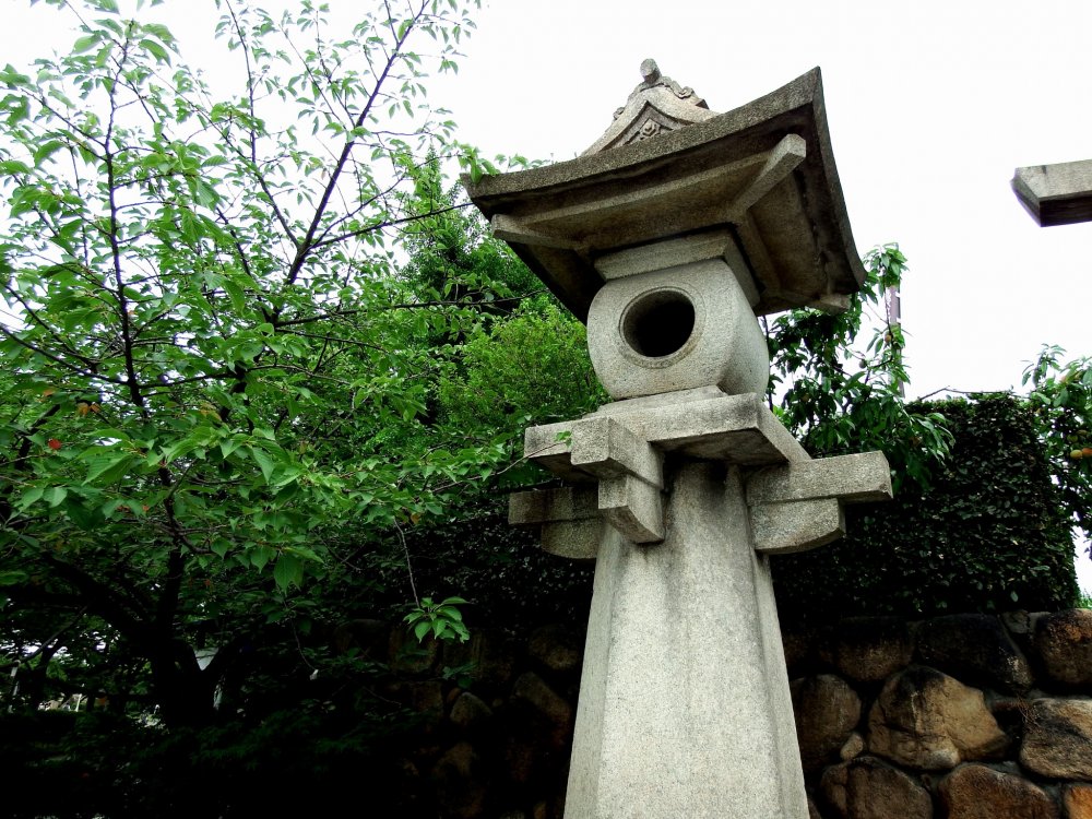 Đèn lồng bằng đá đứng ở lối vào đền Hōkoku