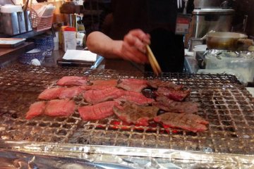 <p>A chef grills the meat over charcoal&nbsp;</p>