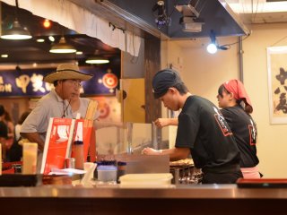 Takoyaki masters painstakingly cooking the delicious Takoyaki.