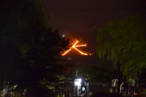 The Kanji character symbolising &quot;Large&quot; being set ablaze on the Daimonji mountain.