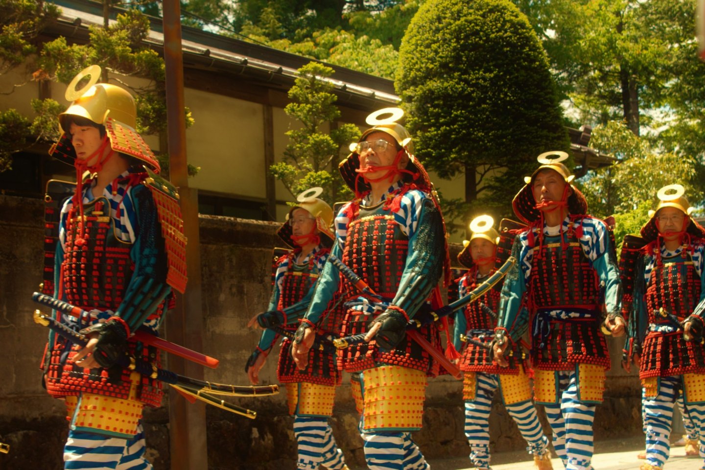 Impressive blue and red samurai warriors in lamellar armor and gold-colored kabuto helmets are an example traditional dress displayed during the procession.