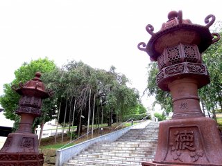 Two lanterns standing tall at the entrance of the shrine