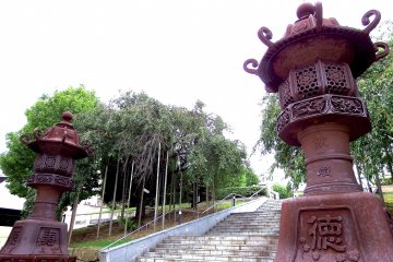 <p>Two lanterns standing tall at the entrance of the shrine</p>