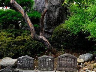 Arrangement with huge rock and small statues