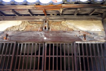 <p>The plaster has crumbled away revealing the construction method of the wall</p>