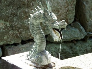 Dragon head spewing water at a water purification font inside Shibata Shrine