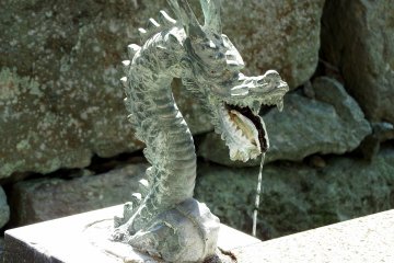 <p>Dragon head spewing water at a water purification font inside Shibata Shrine</p>