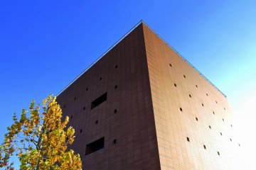 <p>Towering brick-colored building under the blue sky</p>