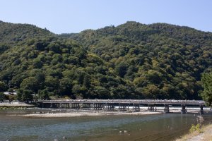 อีกมุมหนึ่งของสะพานโทเก็ตซึเคียว (Togetsukyo Bridge) หรือฉายาสากลว่า Moon Crossing Bridge ที่สะพานดั้งเดิมนั้นสร้างขึ้นตั้งแต่สมัยเฮอัน (Heian Period) ในยุคก่อตั้งกรุงเกียวโต และนี่ก็คือมุมอันงดงามที่ได้รับการขึ้นทะเบียนให้เป็นสถานที่ท่องเที่ยวทางประวัติศาสตร์แห่งญี่ปุ่น (Nationally-designated Historic Site) ใน Cultural Properties of Japan หมวดของ Place of Scenic Beauty ที่ดูแลโดยกระทรวงวัฒนธรรมญี่ปุ่น