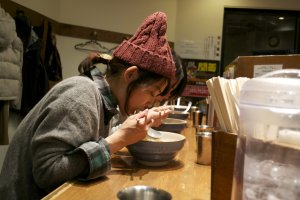 Eating ramen can be a ritual. This customer seems to be enjoying her food