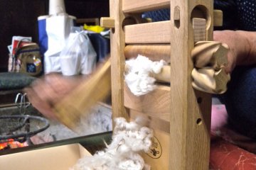 The cotton fibres&nbsp;are pushed out as I spin the cotton gin