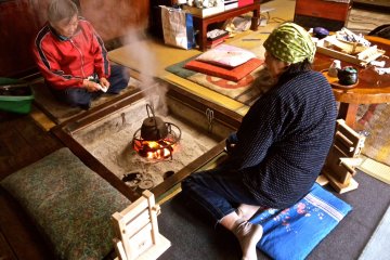 Enjoying the warmth around the irori, where Mrs. Sato prepared my tea