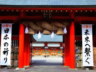 入口大鳥居をくぐり、石畳の道を進むと真っ赤な神門が現れる