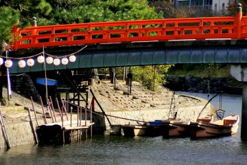 <p>Boats for cormorant fishing under the red pedestrian bridge</p>