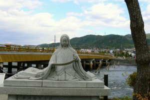 Statue of Murasaki Shikibu with Uji Bridge in the background