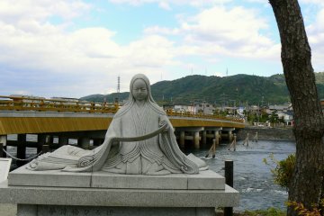 <p>Statue of Murasaki Shikibu with Uji Bridge in the background</p>