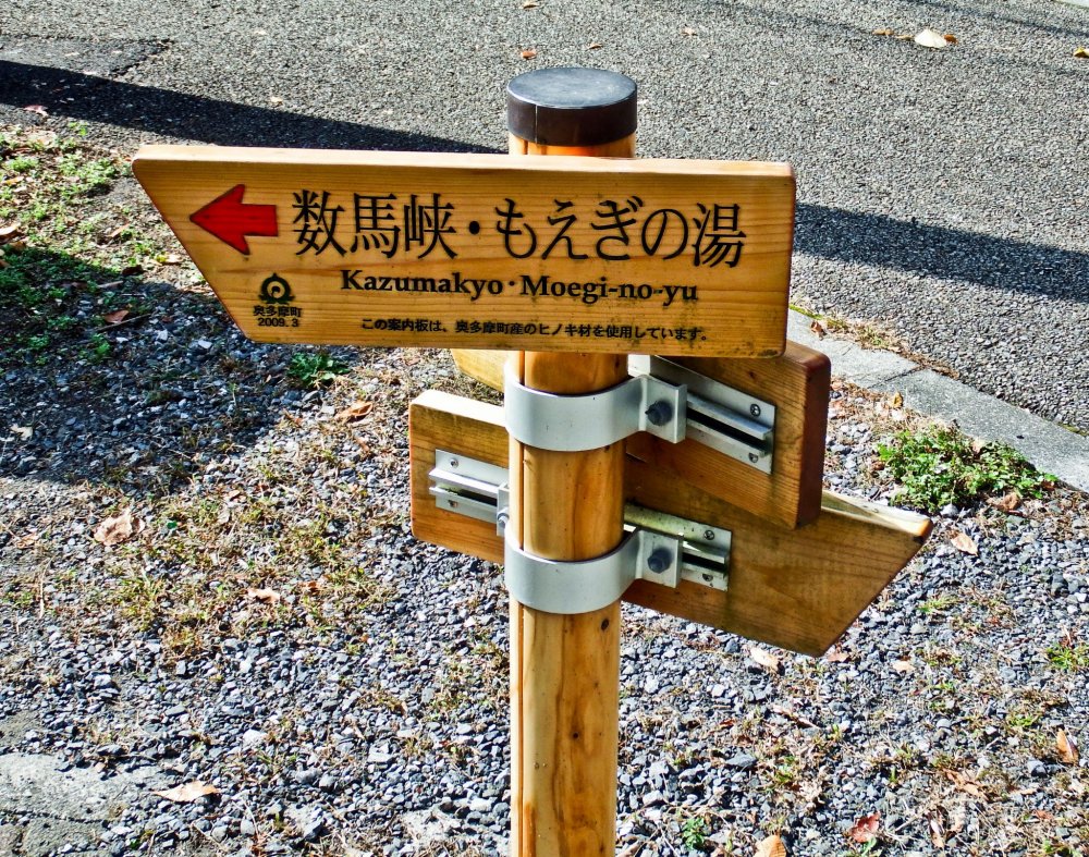 Biển báo đường mòn dẫn đến Hẻm núi Kazuma chỉ cách Ga Shinomaru trên tuyến JR Ome một quãng đi bộ ngắn.