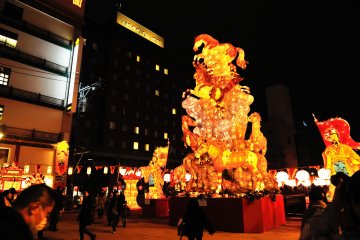 Shinchi Bridge, which connects the city with Chinatown, is bustling with people admiring giant monuments of light