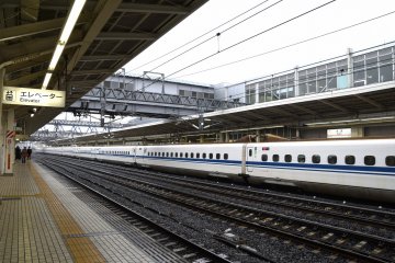 <p>Long cars of the Shinkansen (bullet train) stopping at Maibara</p>