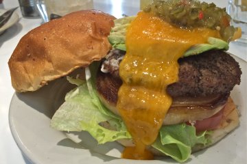 <p>The J.S. Burger is topped with relish, cheddar cheese, lettuce, tomato, and grilled onion. Mmm mmm mmm!</p>