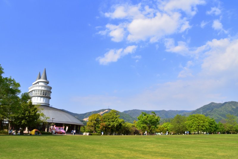 <p>Fukui Green Center under the blue sky. This is the green park area, which includes &#39;Woodream&#39;, an exhibition building, and an open space that has various playing facilities.</p>