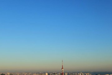 <p>Tokyo Tower beneath a mid day moon</p>