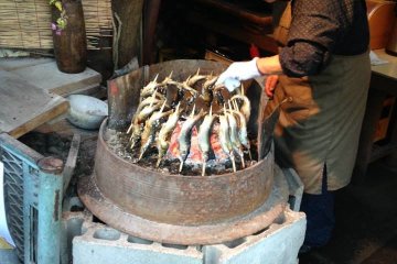 <p>Local shop owner grilling fish</p>