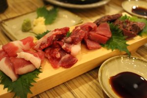 A variety plate of horse meats. The meat on the right is cooked, but the others are mostly raw