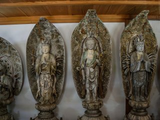 Buddhist statues stand along the corridor