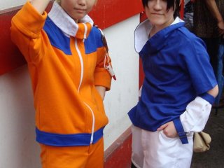 Cosplayers tạo dáng trước cuộc diễu hành. Đây là Uzumaki Naruto và Uchiha Sasuke từ Naruto.
