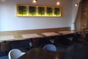 Wine bottles decorate the wall above the tables
