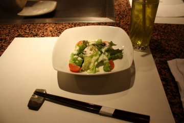 <p>Lunch menu includes a salad, a cooked onigiri, a Japanese omelet and finally the okonomiyaki</p>