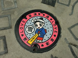 Manhole cover showing Yumomi-chan, the Kusatsu Onsen mascot
